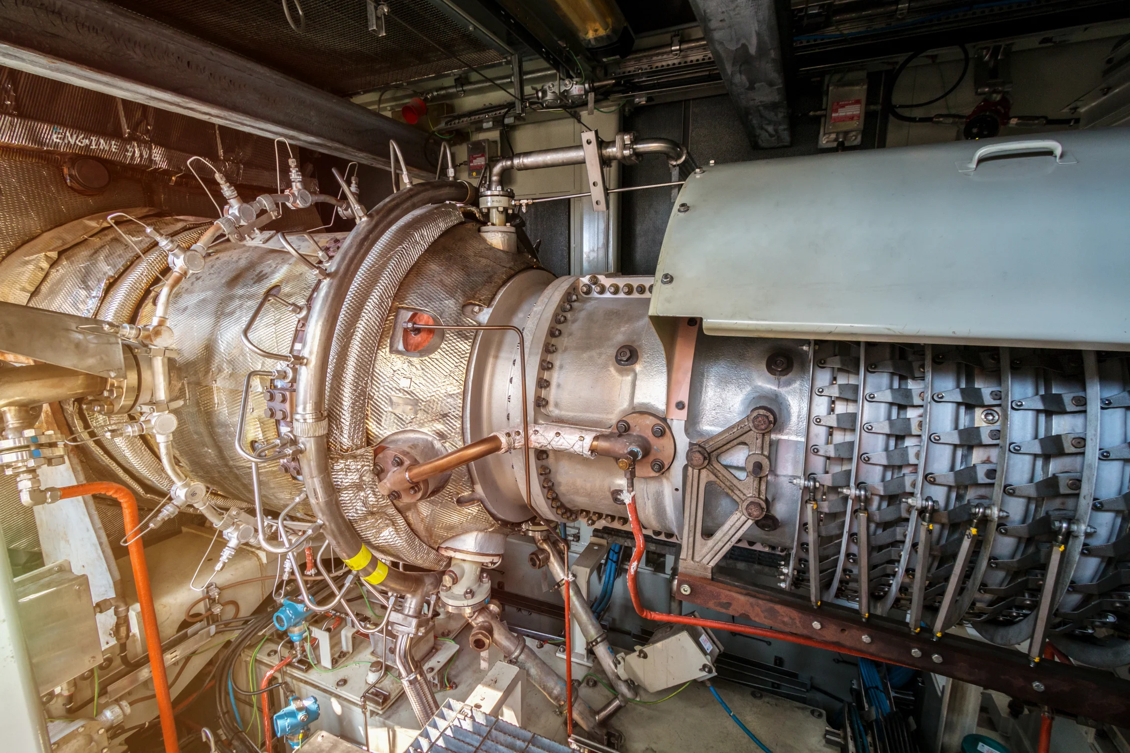 Gas turbine engine of feed gas compressor inside pressurised enclosure on offshore oil and gas platform